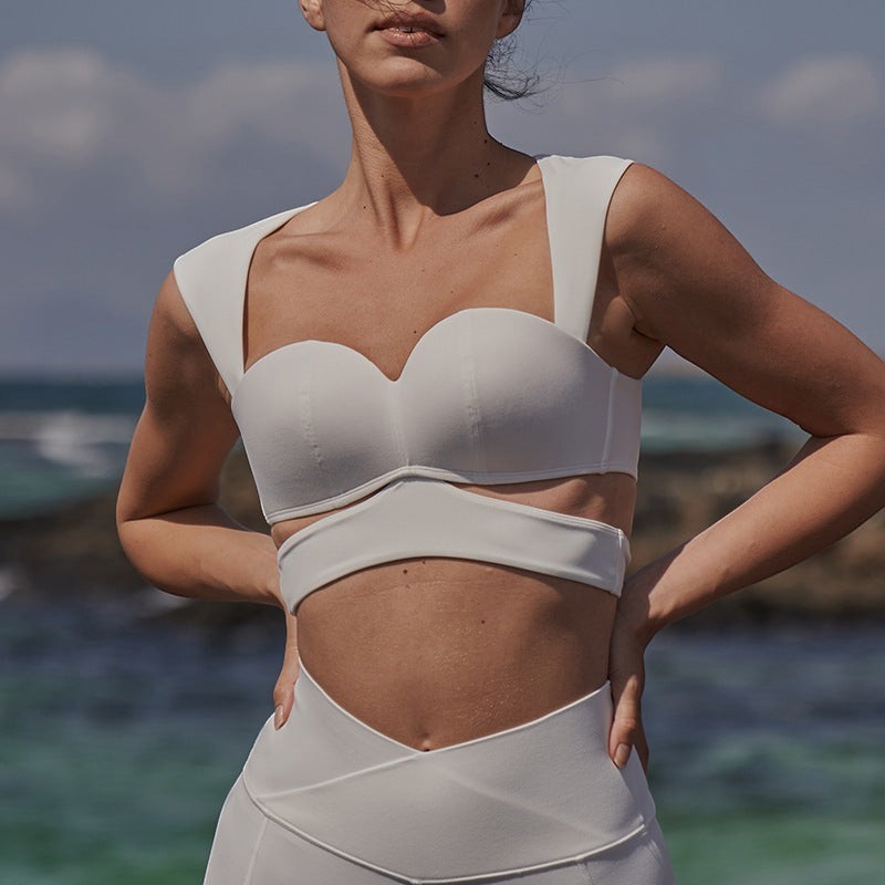 Blush and Bold white sweetheart neckline sports bra with wide straps and matching high-waisted leggings with criss-cross detail.